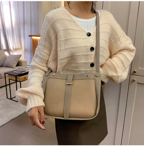 Close-up of beige and tan pebble leather texture with elegant gold buckle detail