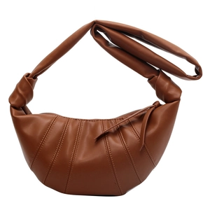 Brown croissant shoulder bag with vertical stitching and knotted strap on white background
