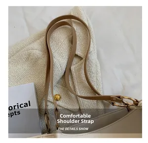 Detail of premium off-white tote bag with brown leather strap and gold metal hardware