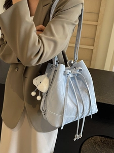 Mint green bucket bag with marble texture and plush cloud pendant on female model