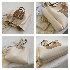 Detail view of cream tote bag with bear print and brown leather contrast stitching