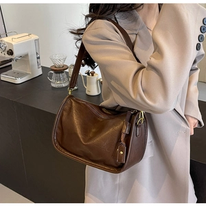 Dettaglio borsa a tracolla vintage in pelle marrone scuro con trama a pieghe eleganti