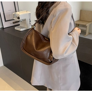 Dettaglio della borsa a tracolla vintage marrone scuro con trama a pieghe e zip