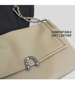 Detail of beige shoulder bag with silver textured buckle and metal chain strap