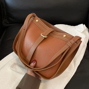 Vintage caramel leather crossbody bag with white stitching and gold buckle hardware
