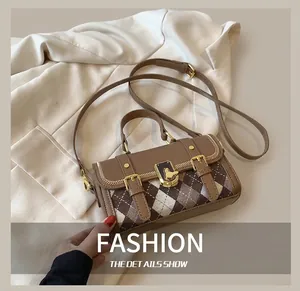 Detail showing the brown vintage satchel with double strap buckles and gold hardware clasp