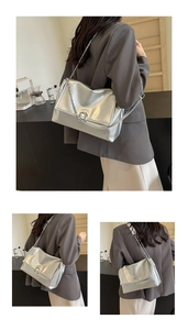 Detail of silver metallic shoulder bag featuring sleek chain strap and metal ring buckle