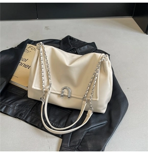 Detail of cream white leather shoulder bag with silver chain and horseshoe buckle