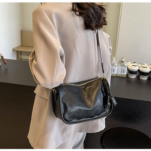 Dettaglio borsa a tracolla vintage nera con zip dorata e incisione del logo Fashion