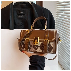 Detail of vintage brown leather handbag with diamond pattern and gold hardware