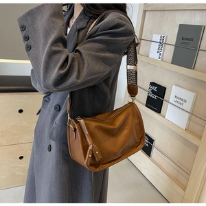 Dettaglio borsa in pelle marrone con tracolla jacquard e goffratura alla moda