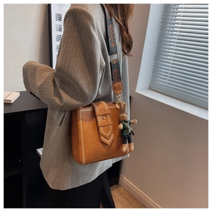 Braune Retro-Schultertasche mit breitem Ethno-Gurt und Plüschhasen-Anhänger
