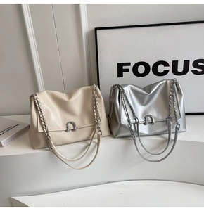 Detail of minimalist chain shoulder bags with metallic buckle and soft faux leather texture