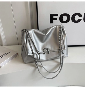 Detailed shot of silver metallic chain bag featuring a decorative horseshoe metal buckle