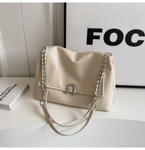 Close-up of cream PU leather crossbody bag with silver U-shaped clasp and chain strap