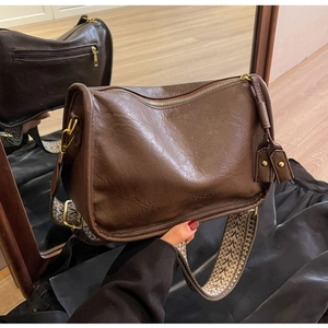 Dettaglio borsa vintage marrone scuro con ampia tracolla in tessuto etnico