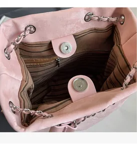 Macro view of pink bucket bag interior with magnetic snap closures and striped lining