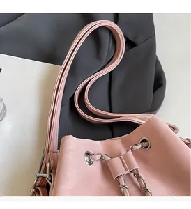 Detailed close-up of pink bucket bag featuring silver chain straps and durable handles