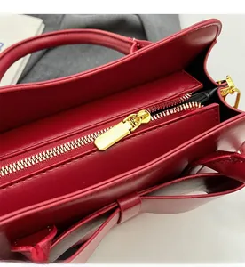 Detail of high-quality golden zipper and red faux leather texture on the bridal handbag