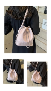 Detail of pink lavender bucket bag with matte finish, drawstring, and metal chain