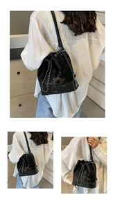 Detail of black drawstring bucket bag with silver chain and MO&H BAGS logo on base