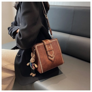 Details der braunen Vintage-Lederhandtasche mit V-Nähten und Hasen-Anhänger