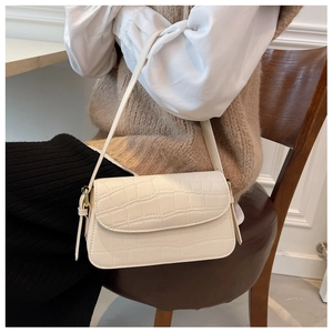 Close-up of cream white crocodile texture shoulder bag with elegant metal hardware