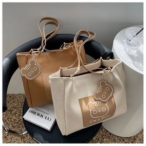 Detail view of large tote bags in brown and cream colors with cute bear prints