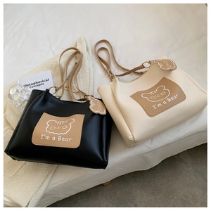 Detail of classic black and beige tote bags with cute cartoon bear pattern and soft texture