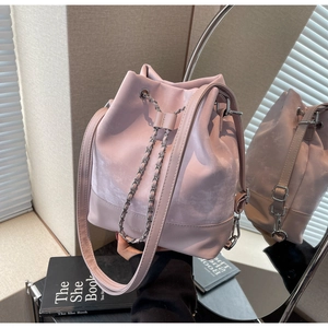 Detailed mirror view of a pink drawstring bucket bag with silver metal chain and leather strap