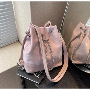 Detailed macro view of pink matte bucket bag with silver chain and drawstring closure