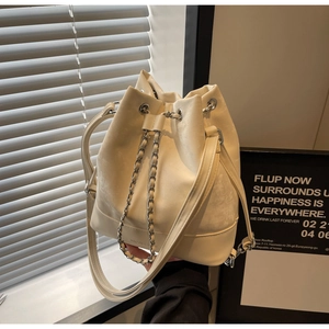 Detailed shot of off-white bucket bag featuring silver chain drawstring and brand logo
