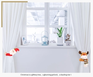 Gros plan d'attaches de rideaux Père Noël et Renne dans un décor de maison festif