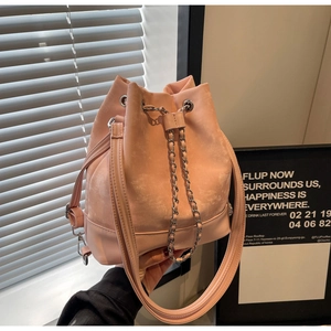 Detail of light pink bucket bag showing suede texture and silver chain drawstring