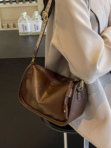 Borsa a tracolla in pelle marrone scuro retrò con tracolla intrecciata indossata da modella