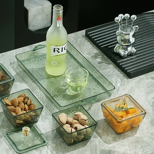 Green and amber textured glass snack serving set with gold handles on marble tray