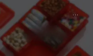 Detail of red divided snack platter showing four compartments filled with assorted nuts and candy