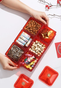 Top-down view of a red translucent 6-compartment snack tray for nuts and candies