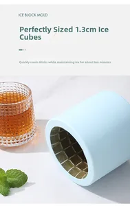 Detail of light blue silicone ice mold making 1.3cm cubes next to a glass of iced drink