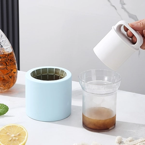 Blue silicone ice cube maker with press mold on marble surface with summer drinks
