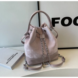 Detail of pink velvet and leather bucket bag featuring silver chain drawstring and handle