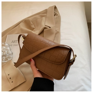 Detailed view of vintage brown crocodile embossed leather shoulder bag with gold hardware