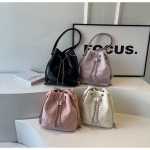Group shot of colorful drawstring bucket bags with silver chains on white display steps