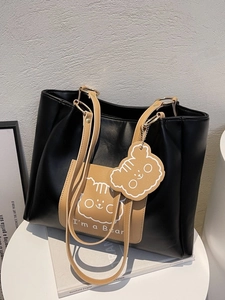 Fashionable black and yellow leather tote bag with bear motif and cute charm
