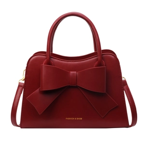 Elegant red wedding handbag with oversized bow detail and gold hardware for brides