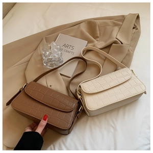Close-up of brown and beige crocodile pattern baguette bags with vintage gold hardware