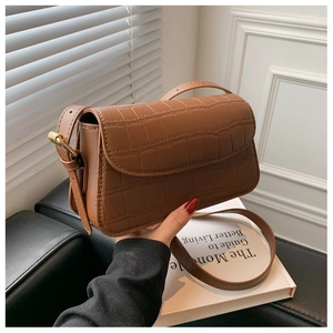 Detailed view of brown crocodile texture leather shoulder bag with golden metal buckle