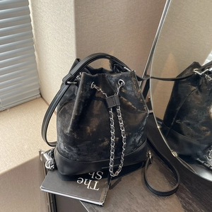 Chic black bucket bag with gold speckled coating and chain drawstring for stylish travel