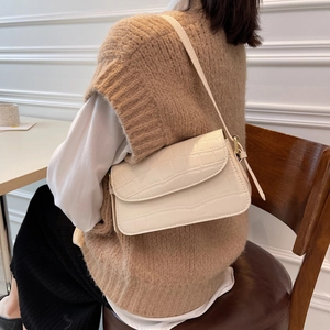 Chic off-white crocodile pattern shoulder bag shown on model in a minimalist setting