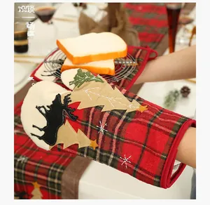 Close-up of heat-resistant Christmas baking glove with plaid pattern and elk appliqué